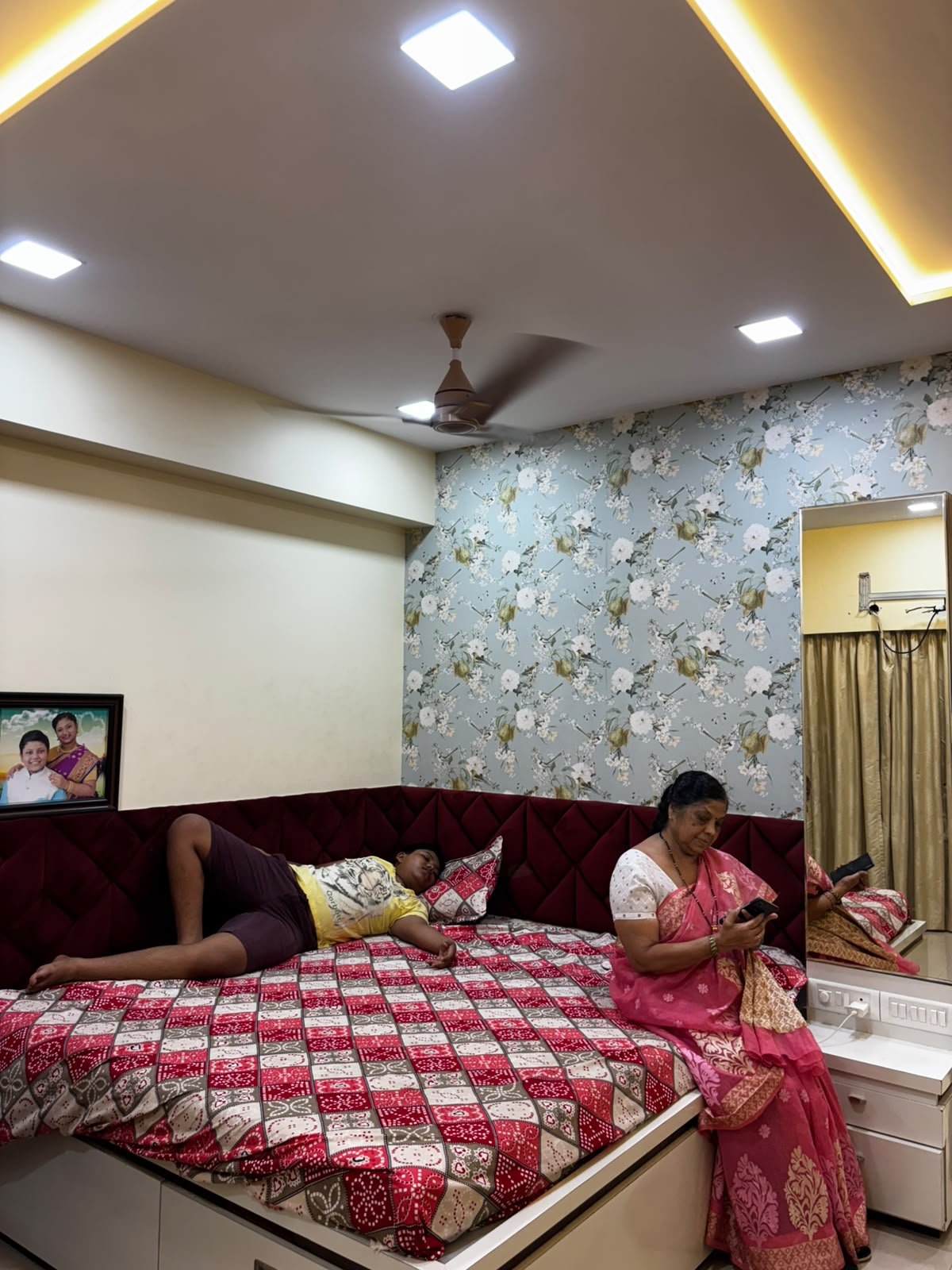 Parent bedroom with upholstered bed and floral feature wall